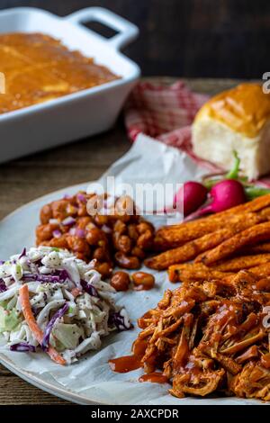 Cuisine du sud des États-Unis. Barbecue végétalien-fruits, coleslaw, pommes de terre douces épicées cuites au four et haricots cuits au barbecue. Banque D'Images