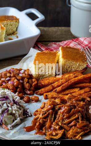 Cuisine du sud des États-Unis. Barbecue végétalien-fruits, coleslaw, pommes de terre douces épicées cuites au four et haricots cuits au barbecue. Banque D'Images