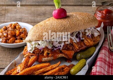 Sandwich végétalien. Pain à la hougie de blé entier avec des fruits à la consommation et des coleslaw. Frites de patate douce cuites sur le côté et haricots cuits au four. Banque D'Images