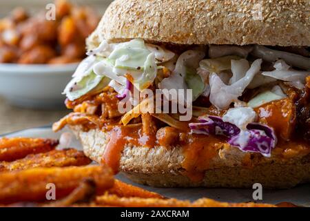 Sandwich végétalien. Pain à la hougie de blé entier avec des fruits à la consommation et des coleslaw. Frites de patate douce cuites sur le côté et haricots cuits au four. Banque D'Images