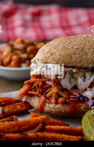 Sandwich végétalien. Pain à la hougie de blé entier avec des fruits à la consommation et des coleslaw. Frites de patate douce cuites sur le côté et haricots cuits au four. Banque D'Images