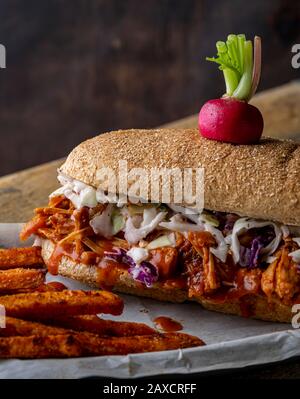 Sandwich végétalien. Pain à la hougie de blé entier avec des fruits à la consommation et des coleslaw. Frites de patate douce cuites sur le côté et haricots cuits au four. Banque D'Images