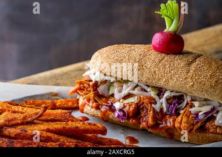 Sandwich végétalien. Pain à la hougie de blé entier avec des fruits à la consommation et des coleslaw. Frites de patate douce cuites sur le côté et haricots cuits au four. Banque D'Images