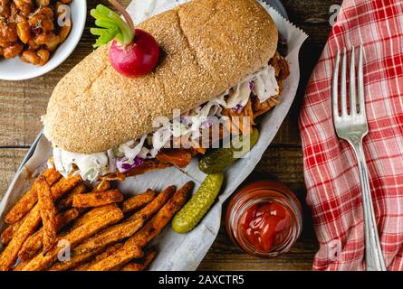 Sandwich végétalien. Pain à la hougie de blé entier avec des fruits à la consommation et des coleslaw. Frites de patate douce cuites sur le côté et haricots cuits au four. Banque D'Images