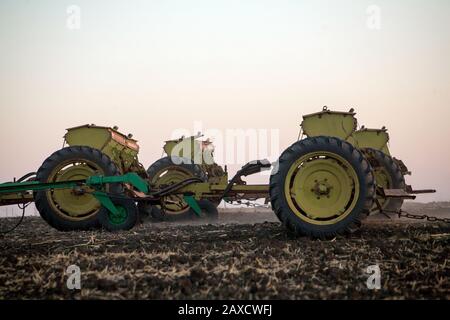 Semoirs mécaniques agricoles de cultures céréalières. Le tacteur à semoir saute le grain dans le champ. Un agriculteur d'un tracteur avec semoir traite le champ. Banque D'Images