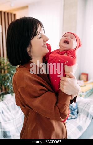 La mère tient un bébé pleurant et hurlant dans ses bras. Banque D'Images