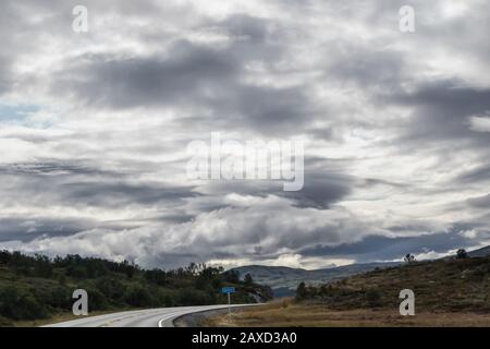 Route des montagnes en Norvège. Ciel panoramique épique avec vue sur les nuages. Voyager en voiture, tourisme de la nature. Paysage nuageux spectaculaire, couleurs vives du nord, numérisation Banque D'Images