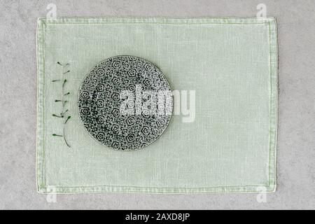 Plaque en céramique verte avec motif fleuri sur l'étiquette en lin. Banque D'Images