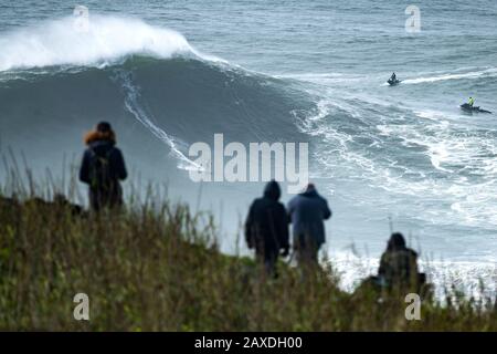 Un surfeur non identifié est vu monter une vague pendant le Défi De Surf Nazaré Tow qui s'est tenu à la plage Praia do Norte, à Nazaré.Nazaré Tow Surfing Challenge est une compétition de grande vague de la Ligue mondiale de surf qui a eu lieu sur la plage Praia do Norte. Il a profité de l'énorme houle qui a frappé la côte portugaise le 11 février. Banque D'Images