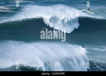 Le surfeur Kai Lenny (Hawaï) est vu rouler une vague pendant le Nazaré Tow Surfing Challenge tenu à la plage Praia do Norte, à Nazaré.Nazaré Tow Surfing Challenge est une compétition de grande vague de la Ligue mondiale de surf qui a eu lieu sur la plage Praia do Norte. Il a profité de l'énorme houle qui a frappé la côte portugaise le 11 février. Banque D'Images