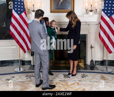 La première dame des États-Unis Melania Trump pose avec Robin Schneider, sa fille Ellie Schneider et son mari lors d'une réception pour les invités de la galerie de l'État de l'Union dans la salle de réception diplomatique de la Maison Blanche le 4 février 2020 à Washington, DC. Banque D'Images