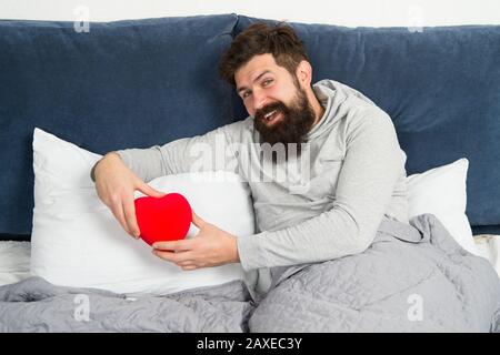 Les hippers barbus ont besoin d'amour. Manque d'amour. Idées romantiques. Lieu vacant. Homme se reposant seul dans le lit. À la recherche d'un partenaire. Prenez soin du cœur. L'amour et les relations. Saint Valentin. Soins de santé. Banque D'Images