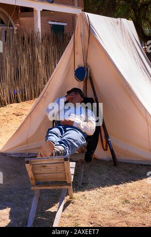 Soldat des années 1880 armée américaine 5ème cavalerie snoozing à l'extérieur de sa tente à fort Lowell à Tucson AZ Banque D'Images