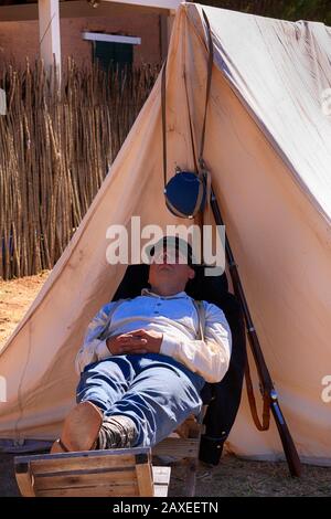 Soldat des années 1880 armée américaine 5ème cavalerie snoozing à l'extérieur de sa tente à fort Lowell à Tucson AZ Banque D'Images