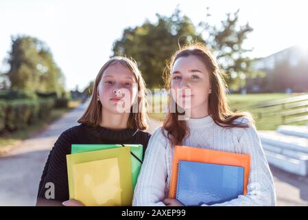 Deux filles écolière amies 12-14 ans, portrait d'été dans la ville dans la rue, dans les mains des carnets de dossiers manuels, se reposant après l'école dans Banque D'Images