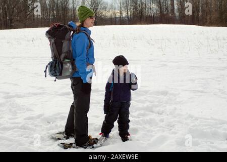 Jeune Femme Et Raquette Pour Garçon Sur Winter Trail-Vandenbout-11 Banque D'Images