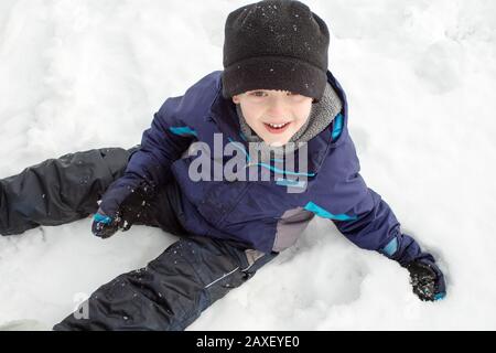 Hiver Boy Assis Dans La Neige De Dessus Banque D'Images