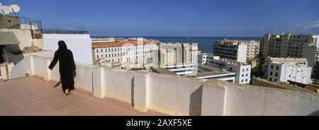 Vue arrière d'une femme marchant sur le toit, Alger, Algérie Banque D'Images