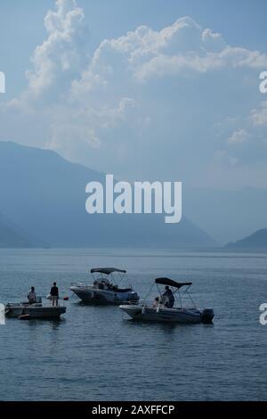 Trois bateaux de loisirs sur le lac de Côme, Lombardie Italie, un beau lac alpin de villages pittoresques, villas luxueuses, palais, paysage dramatique Banque D'Images