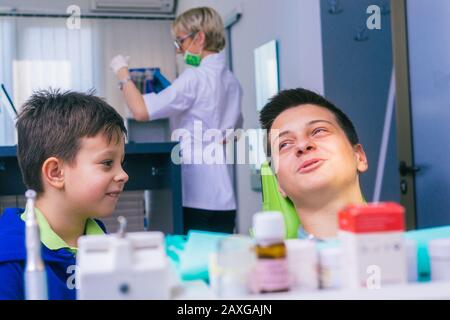 Deux jeunes frères heureux assis dans un bureau de dentiste et attendant un examen dentaire Banque D'Images