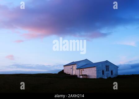 Petite maison de gardien de phare sur La Réserve naturelle de Dyrholaey, Islande, Europe. Photographie de paysage Banque D'Images