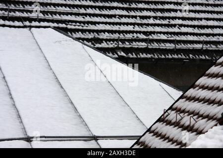 Divers toits couverts de neige par temps de rosée se ferment, humeur hivernale en février sur un jour nuageux Banque D'Images