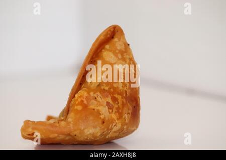 Fond blanc avec les aliments végétariens samosa ou samosas de pomme de terre. Cuisine de rue spéciale indienne. Célèbre samosa alimentaire indien rempli de mélange de pommes de terre, Indi Banque D'Images