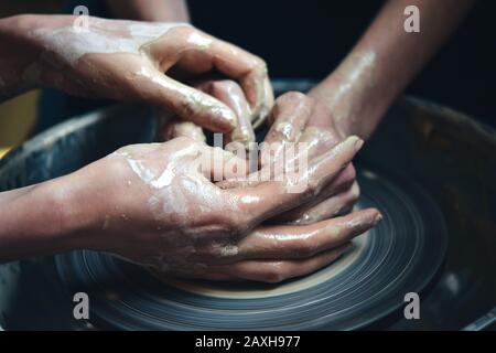 Deux personnes moulez un pot d'argile à partir d'argile blanche. Maître potter enseigner de l'argile dans le gros plan de l'atelier Banque D'Images