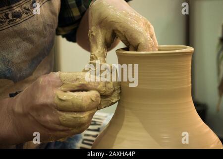 Le pot moule la pichet en argile pot de fermeture. Atelier sur la fermeture de l'argile blanche sculptée. Mains sales dans l'argile. Fabrication de produits céramiques . Créatif artistique. Banque D'Images