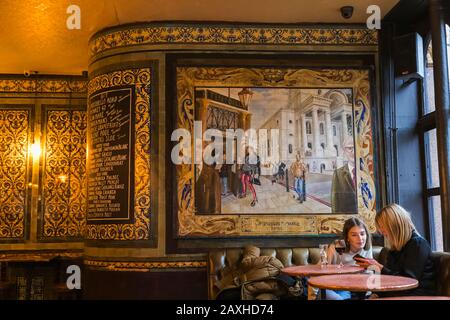 Angleterre, Londres, Shoreditch, Spitafields, The Ten Bells Pub, Deux Femmes Clientes Regardant Iphones Banque D'Images