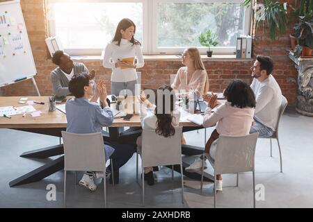 Femme asiatique faisant rapport devant l'équipe d'affaires Banque D'Images