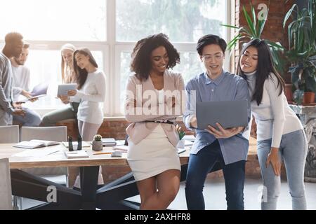 Groupe diversifié de collègues ayant une conversation au bureau Banque D'Images