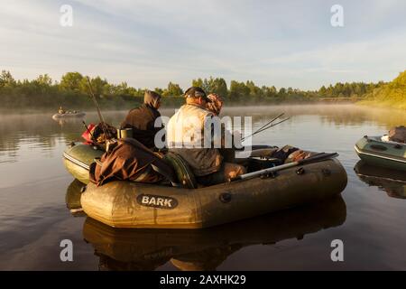 Tuzha, Russie - 12 juin 2019: Les pêcheurs pêchent le poisson sur un bateau en caoutchouc sur une rivière forestière. Rivière Pizhma le matin. Banque D'Images