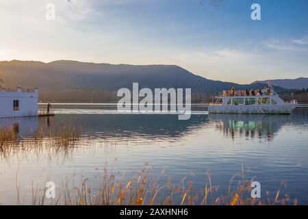 Bateau touristique près de la maison de pêche construite sur le lac de Banyoles, Gérone, Catalogne, Espagne Banque D'Images