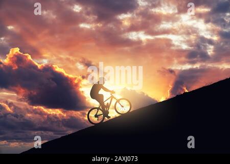 Vélo de montagne sur une rampe contre ciel nuageux. Atteindre le concept de difficulté et d'amélioration Banque D'Images