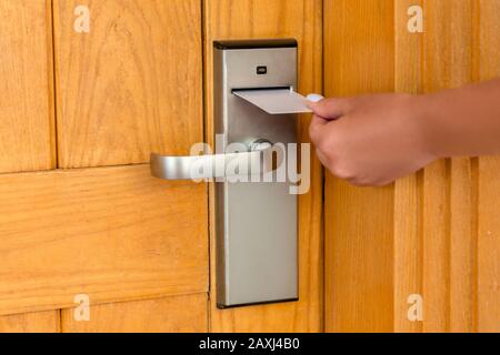 Mettre la main féminine et la tenue de l'interrupteur à clé magnétique pour ouvrir la porte de la salle de l'hôtel. Banque D'Images