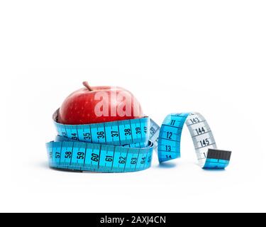pomme rouge isolée enveloppée de ruban de mesure sur fond blanc. Régime alimentaire et concept de vie saine Banque D'Images