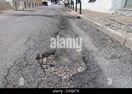 Surface endommagée de la rue locale à Albufeira, Portugal. Concept d'entretien des routes. Banque D'Images