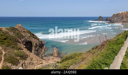 Vagues de l'océan Atlantique se brisant sur la pointe rocheuse et la baie avec plage de sable, Praia de Odeceixe, Algarve, Portugal, Europe du Sud Banque D'Images