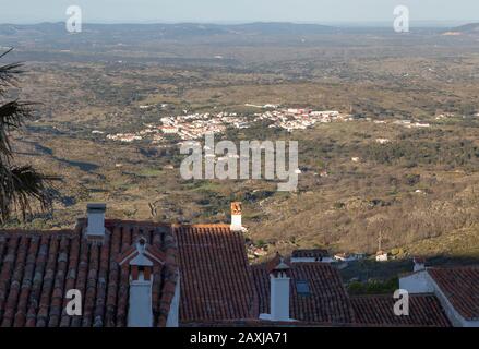 Vue sur les toits jusqu'aux basses terres en dessous et vers les collines et la frontière avec l'Espagne. Le village de Santo António das Areias, Portugal Banque D'Images