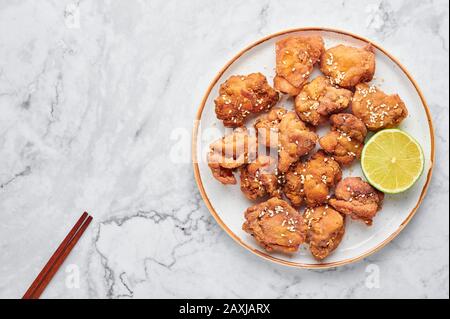 Karaage de poulet en plaque blanche sur fond de marbre blanc. Karaage est un plat de cuisine japonaise traditionnel avec du poulet mariné frits. Espace de copie, Banque D'Images