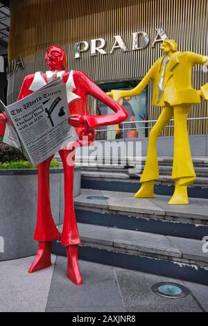 Des personnages colorés et abstraits de clients à l'extérieur D'ION Orchard, un centre commercial d'Orchard Road, Singapour, avec une boutique haut de gamme Prada dans le b/g Banque D'Images