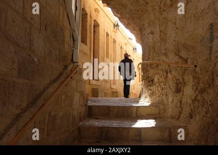 Une promenade touristique le long d'un étroit couloir avec des chambres de chaque côté au monastère grec orthodoxe Saint de Sarantarion montagne ou Temptation construit sur les pentes du Mont de Temptation situé le long d'une falaise surplombant la ville de Jéricho dans les Territoires palestiniens situés près de la rivière Jordan dans La Cisjordanie, Israël Banque D'Images