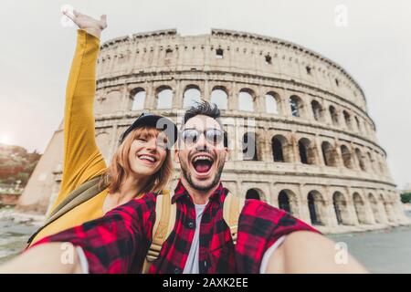 Deux touristes prennent un selfie en face du Colisée de Rome, Italie Banque D'Images
