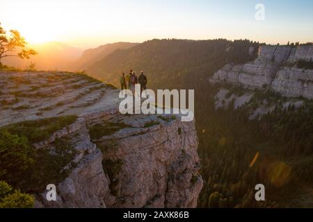 Wanderer beim Sonnenaufgang am Creux du Van Banque D'Images