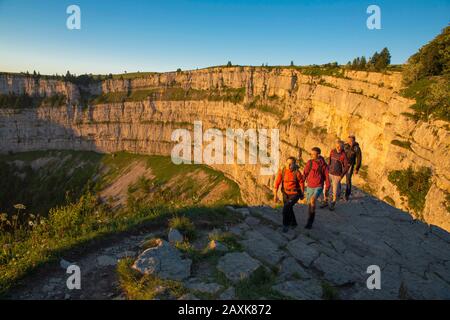 Wanderer beim Sonnenaufgang am Creux du Van Banque D'Images