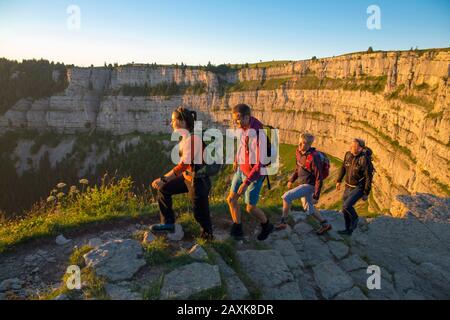 Wanderer beim Sonnenaufgang am Creux du Van Banque D'Images