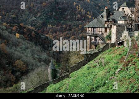 Pentes boisées devant des maisons en pierre, Conques, France Banque D'Images