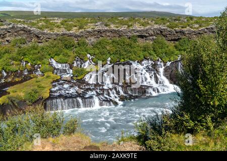 Petite chute d'eau en Islande – Hraunfosar – lors d'une journée ensoleillée en été Banque D'Images