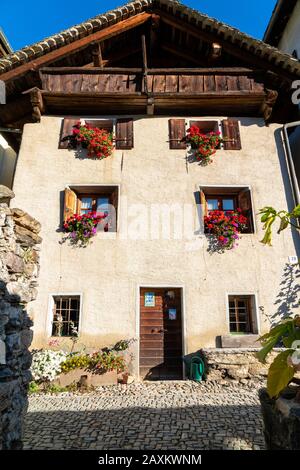 Façade de maison décorée avec un pot de fleurs dans la vieille allée de Soglio, canton de Graubunden, Suisse Banque D'Images